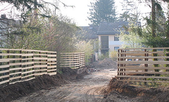 Schutzäune an Baustelleneinfahrt, Baumschutzmaßnahmen München